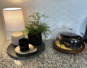kitchen counter with plant, lamp and cake