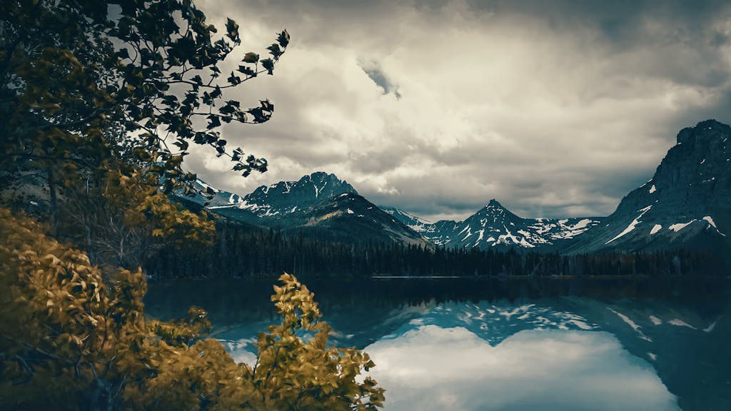 Captivating mountain landscape with dramatic clouds and a serene reflective lake, showcasing nature's beauty.