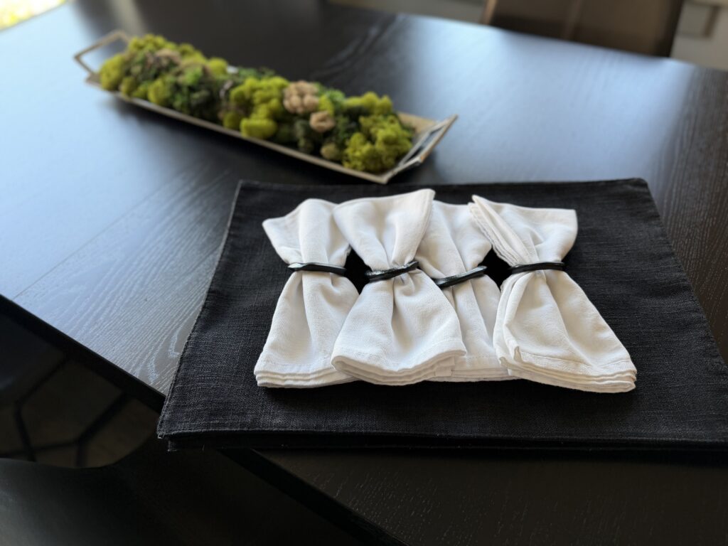 greenery on a black table with white napkins